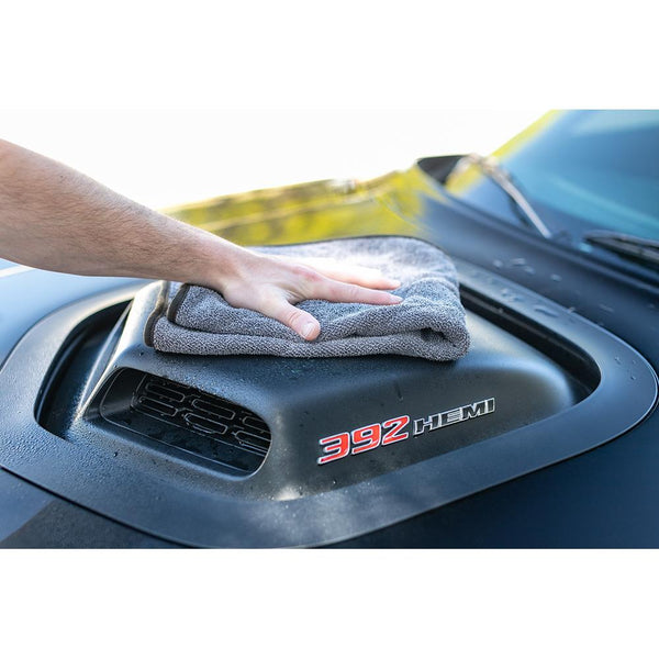 Using a 20"x24" Double Twistress microfiber towel from The Rag Company to dry the hood cowl of a black Dodge Challenger with a 392 hemi engine. The towels have a ButerSoft scratchless suede edge that is safe on paint, trim, and glass