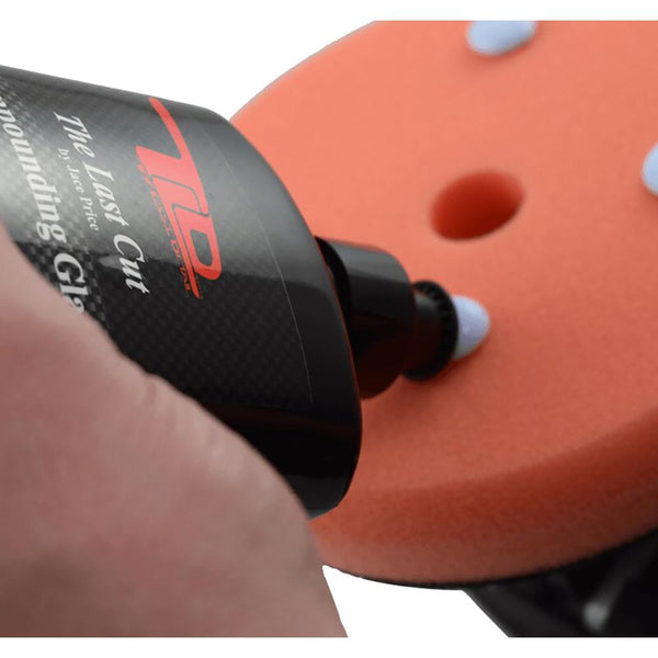A bottle of TLD The Last Cut pouring product onto polishing pad.