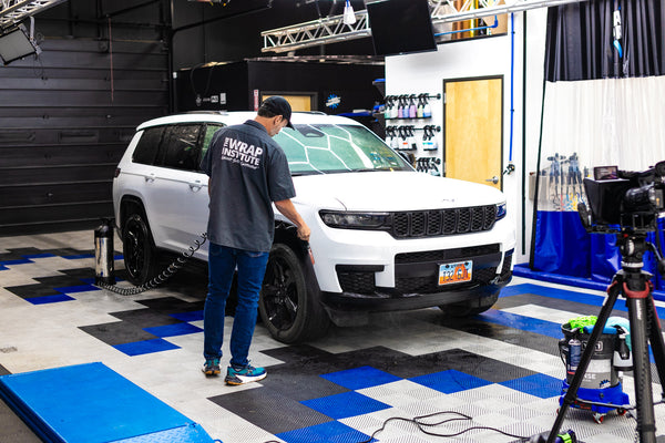 A person cleaning a Jeep Cherokee with an IK Sprayer.