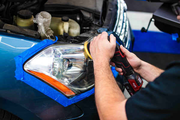 A person using the Koch Chemie Headlight Polish Kit to polish a headlight.