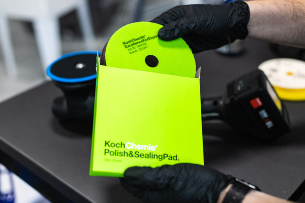 A person pulling a Koch Chemie Polish and Sealing Pad out of its packaging.