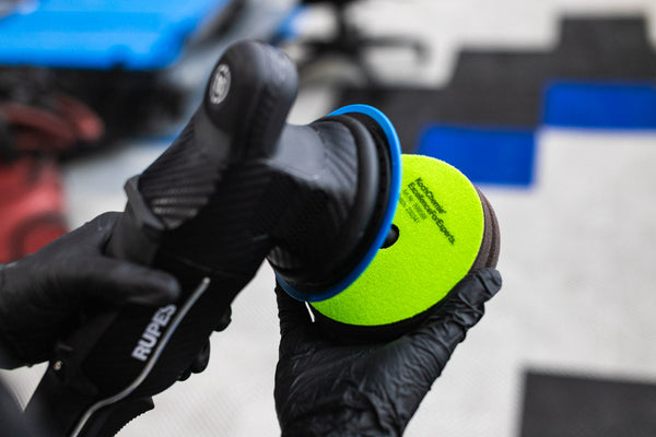 A person applying a Koch Chemie Polishing and Sealing Pad to a Polisher.