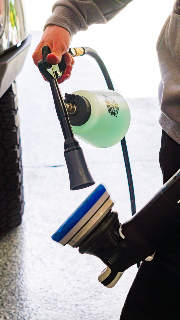 A person spraying a polishing pad with an Ultra Air Blaster Plus.