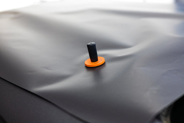 A close up of a Yellotools Speedmag on a car dent.