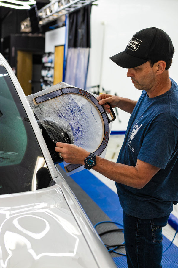 A person using the Yellotools Wrap U Ezee on a car side mirror.