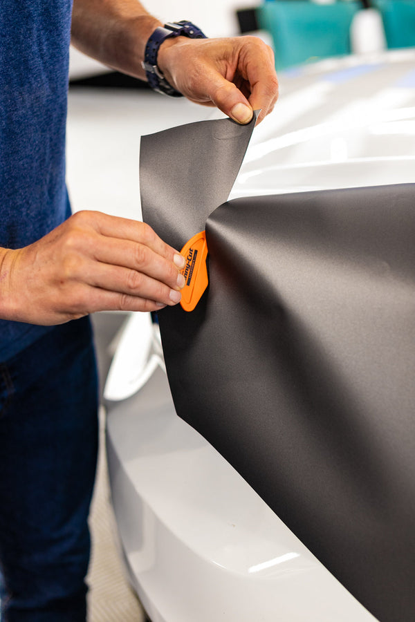 A person using the Yellotools Tinny Cut to cut vinyl.