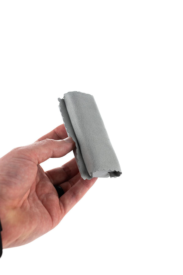 A hand holding the Wrap N' Tuck over a white background.